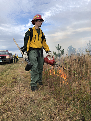 drip torch being used to set fire during a controlled burn exercise